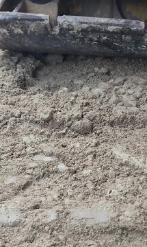 Vertical 9:16 video of a worker operating a plate compactor on a construction site.