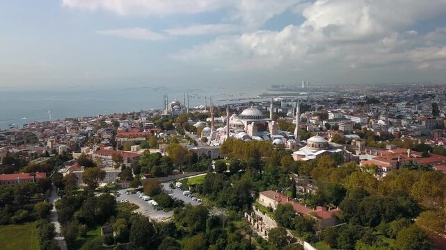 Aerial view of Hagia Sophia and Hagia Irene surrounded by autumn trees in Sultanahmet with Blue Mosque and Marmara Sea in background, Istanbul