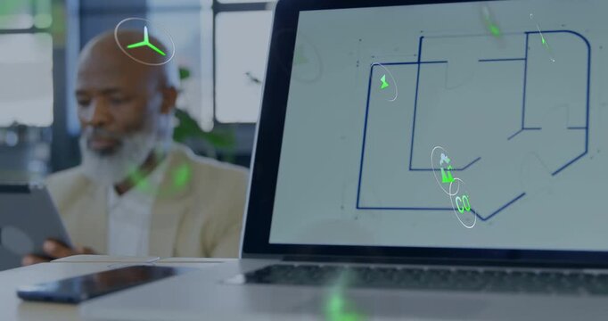 Senior male tapping tablet in design office, green icons popping over tablet and highlighting plan