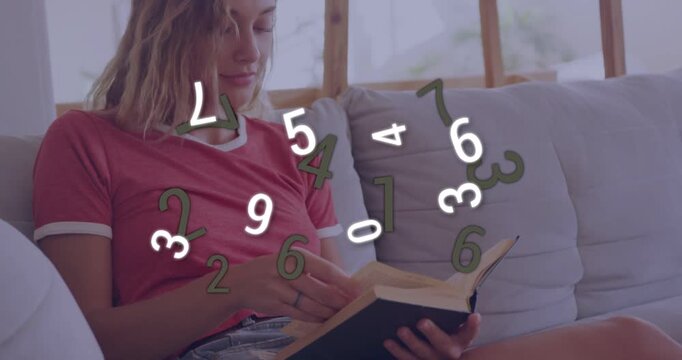 Woman opening book on sofa causing digits overlay swirling across hands, studying for education
