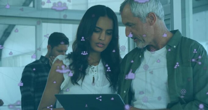 Woman holding tablet and man leaning in scrolling and starting social icons while camera tightening