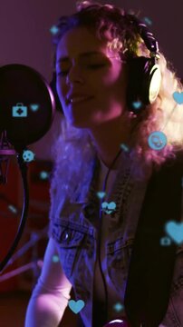 Vertical video: Camera focusing on hands and red guitar, musician playing and singing for vocals