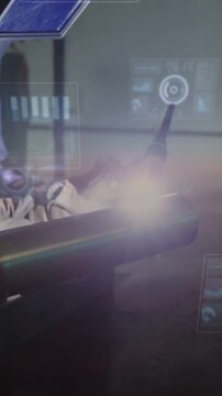 Vertical video: Doctor leaning toward OR table, light activating UI and scope, preparing surgery