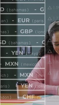 Vertical video: Woman highlighting papers for finance review while tickers scrolling, covering left