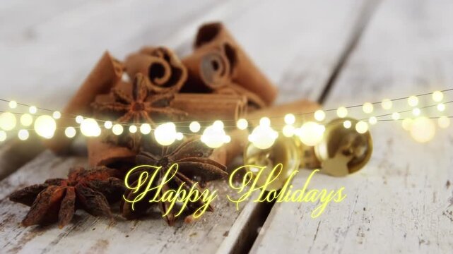 Animation of text, happy holidays, in yellow, over string lights and cinnamon sticks on floorboards