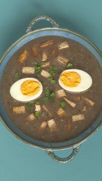Top view of the vegetarian version of traditional Polish zurek soup with tofu and hard-boiled eggs.
