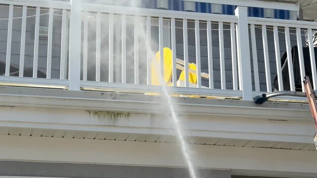 Power washing house and porch with tilt up to top of the house.