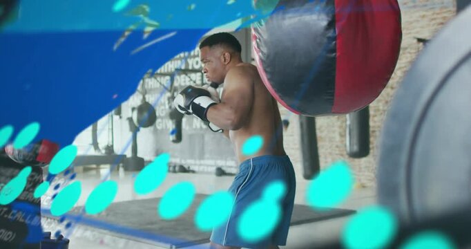 Male boxer starting boxing training by striking heavy bag, blue data overlays tracking punch power
