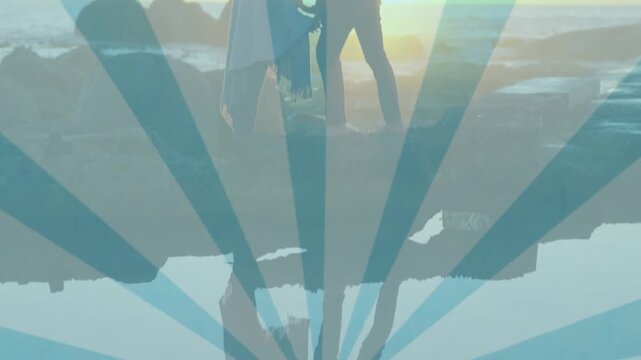 Animation of silhouetted couple standing on rocks with blue rays in background