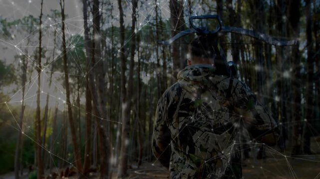Man walking deeper into forest carrying crossbow, glowing technology themed digital network overlay