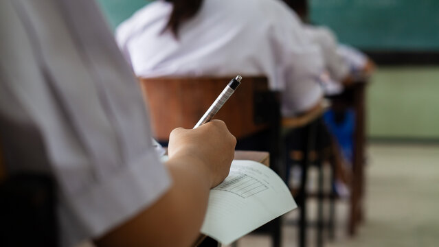 Close-up of Student's Hand Writing on Multiple Choice Exam Paper