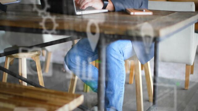 Man bringing hands to laptop and typing for work in tech space, animated gears charts overlaying