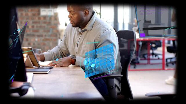 Man at shared desk, tapping tablet and activating holographic tech overlay while analyzing data