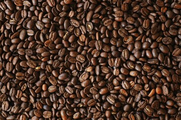 Fototapeta premium Roasted coffee beans background, dark brown espresso bean texture, organic arabica coffee seeds top view, aromatic caffeine ingredient for cafe menu