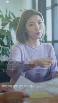 Vertical video: Reacting to paper swap Asian lady in lilac sweater handing papers clapping at table