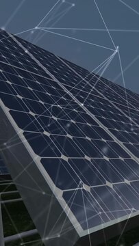 Vertical video: Camera moving between solar panels, tilting up while network overlay mapping grid