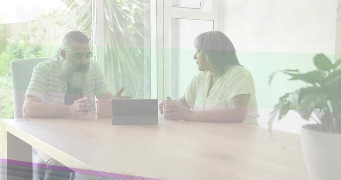 Couple discussing tech at table, tablet; glitches crossing frames, guest entering causing greeting
