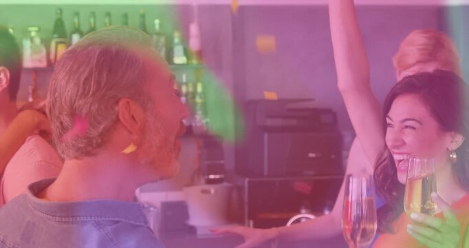 Vertical video: Laughing man and woman in red celebrating at bar with flutes and confetti falling