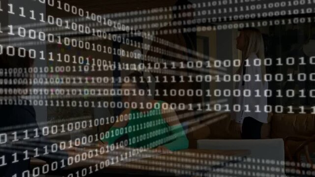 Seated worker using laptop while binary stream clearing, revealing standing peer for tech work
