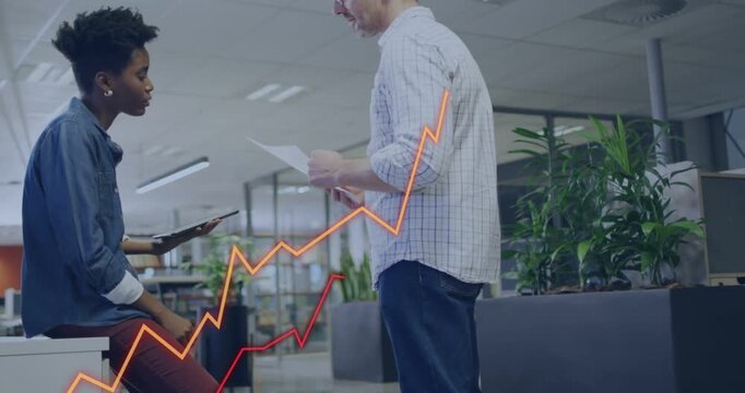Pointing man showing sheet, woman in blue shirt reviewing tablet data at office, graphs rising