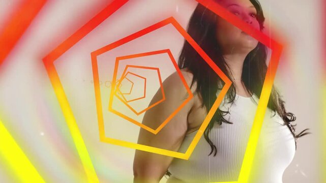 Vertical video: Posing woman in white top moving hands, tilting chin as pentagon spins in studio