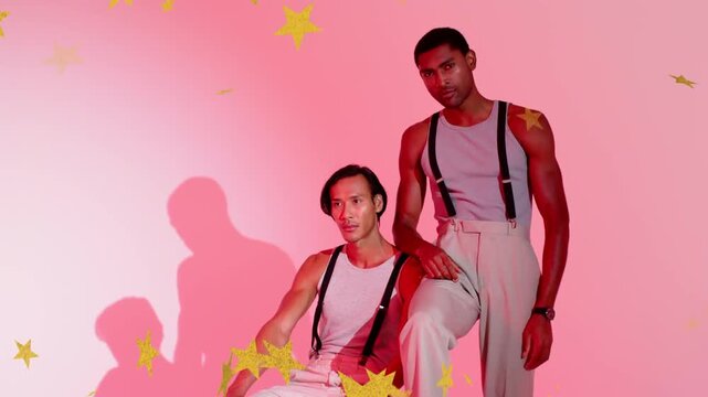 Vertical video: Adjusting pose as yellow stars drifting, two models with suspenders in pink set