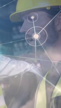 Vertical video: Site worker watching peer pointing, HUD nodes expanding across hard hat for safety