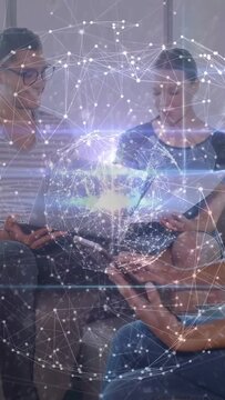 Vertical video: Team tapping phones, tablets and sharing content in tech lounge, globe pulsing