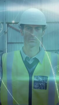 Vertical video: Site worker in hi-vis vest posing while camera panning, showing helmet and HUD