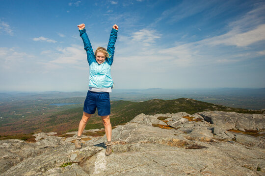 Enthusiastic young female hiker on the summit of Mount Monadnock