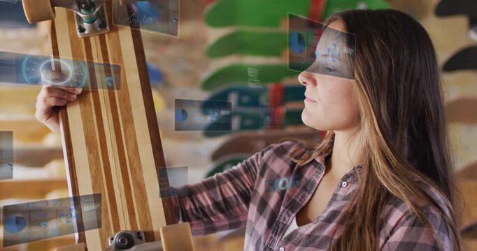 Woman reaching up taking longboard, rotating and checking trucks while shop UI overlay aiding buy