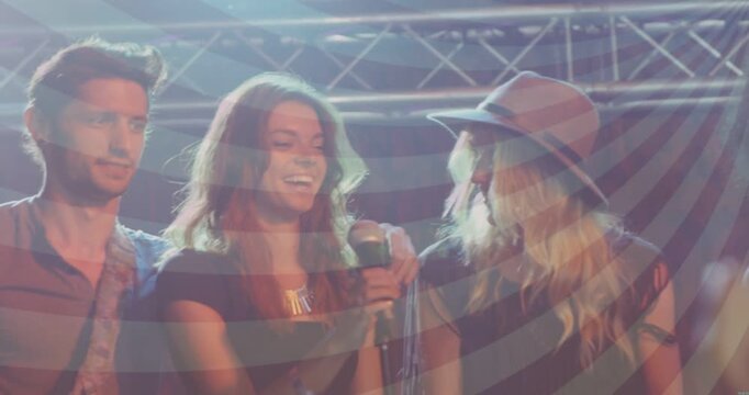 Vertical video: Prompted by lights, lead singer raising prop and mic on stage, hat leaning in
