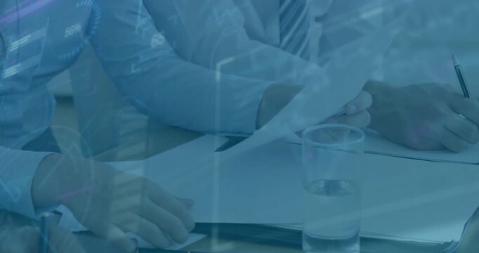 Adjusting colleagues' hands lifting report at meeting table, pen poised starting annotating chart