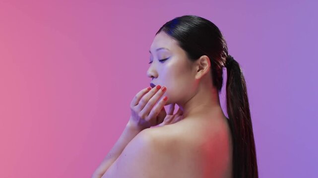 Vertical video: Posing model turning profile to gaze on camera cue in studio, bare shoulders