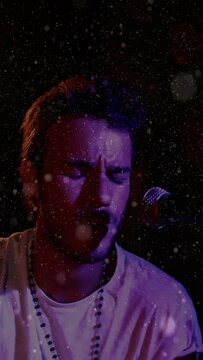 Vertical video: Spotlight cueing singer, raising arm, singing, striking stick, looking, performing