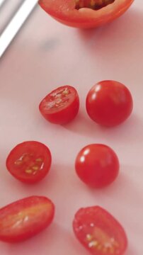 Vertical video: Fork lifting tomato, tomatoes shining, cyan charts sliding over produce for food ad