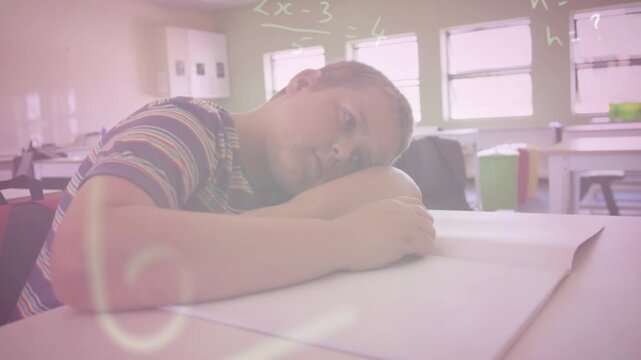 Animation of math formulas over tired caucasian boy lying on desk at school