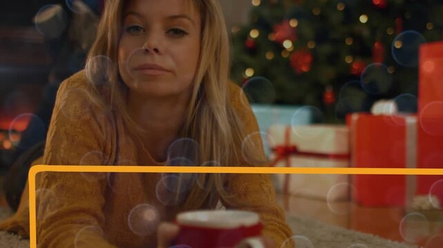 Animation of smiling woman over christmas tree and decorations with yellow frame