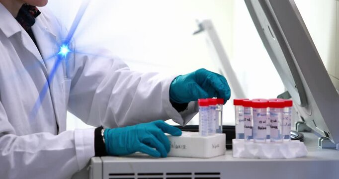 Blue spot of light against mid section of caucasian female scientist putting test-tubes in a machine