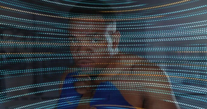 Athlete adopting guard by LED strips performing shadow boxing with light trails for sports training