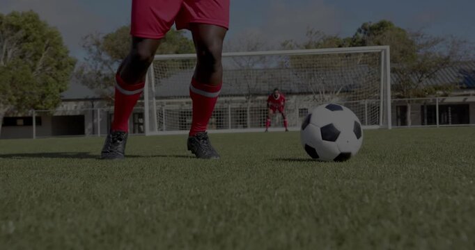 Field player initiating feint, controlling soccer ball in front of goal, preparing sports shot