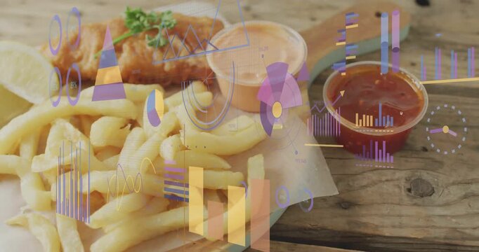 Panning camera revealing plate with fried fish and fries lemon at wooden table with charts moving