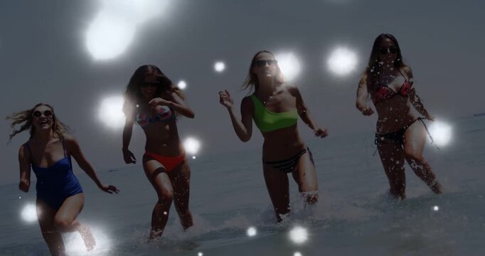 Four women starting waist-deep, running ashore, splashing for swimwear, bokeh overlay floating