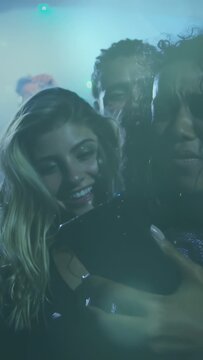 Vertical video: Two women lifting phone, checking screen, singing along with concert singer