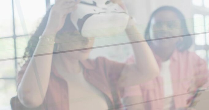 Woman picking up VR headset, fitting straps, activating animated VR demo for colleague in workspace