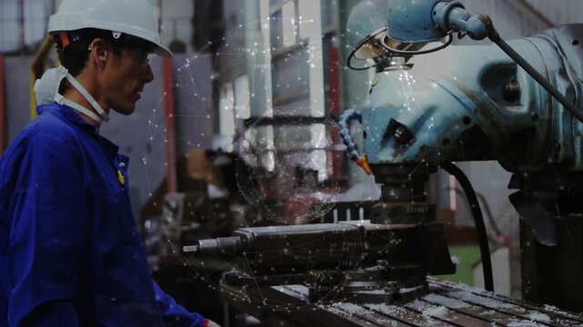 Male machinist watching spindle engaging workpiece, with coolant spray and chips for manufacturing