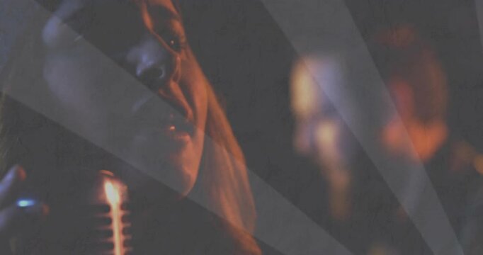 Female singer starting singing with feeling into vintage mic, rays across face, warming light