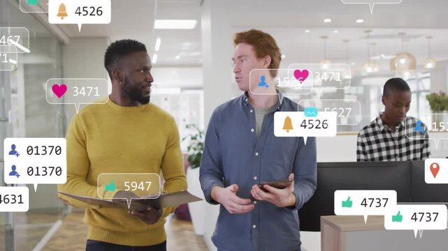 Two male coworkers walking in office, tapping tablet sparking floating likes while checking stats