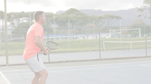 Man in orange tracking tennis lob, shifting feet and raising racket as animated line guiding return