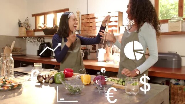 Vertical video: Waving utensil sparking women in aprons miming for fun with charts in kitchen
